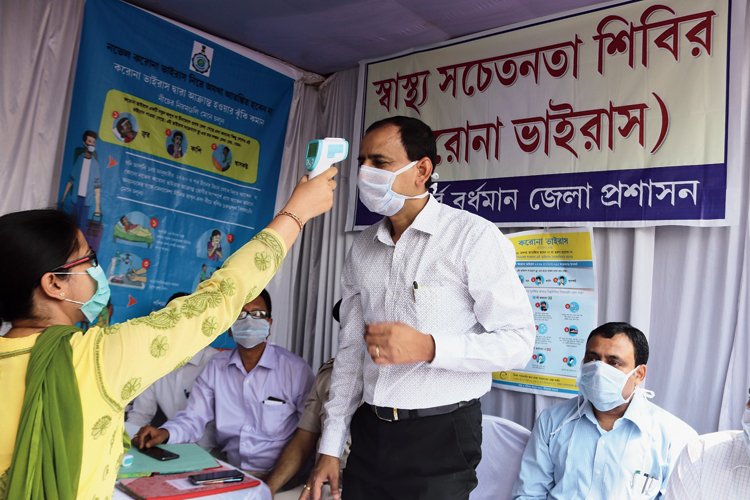 Temperature of East Burdwan district magistrate Vijay Bharti being checked during the launch of a screening camp at the Burdwan railway station on Tuesday. 

