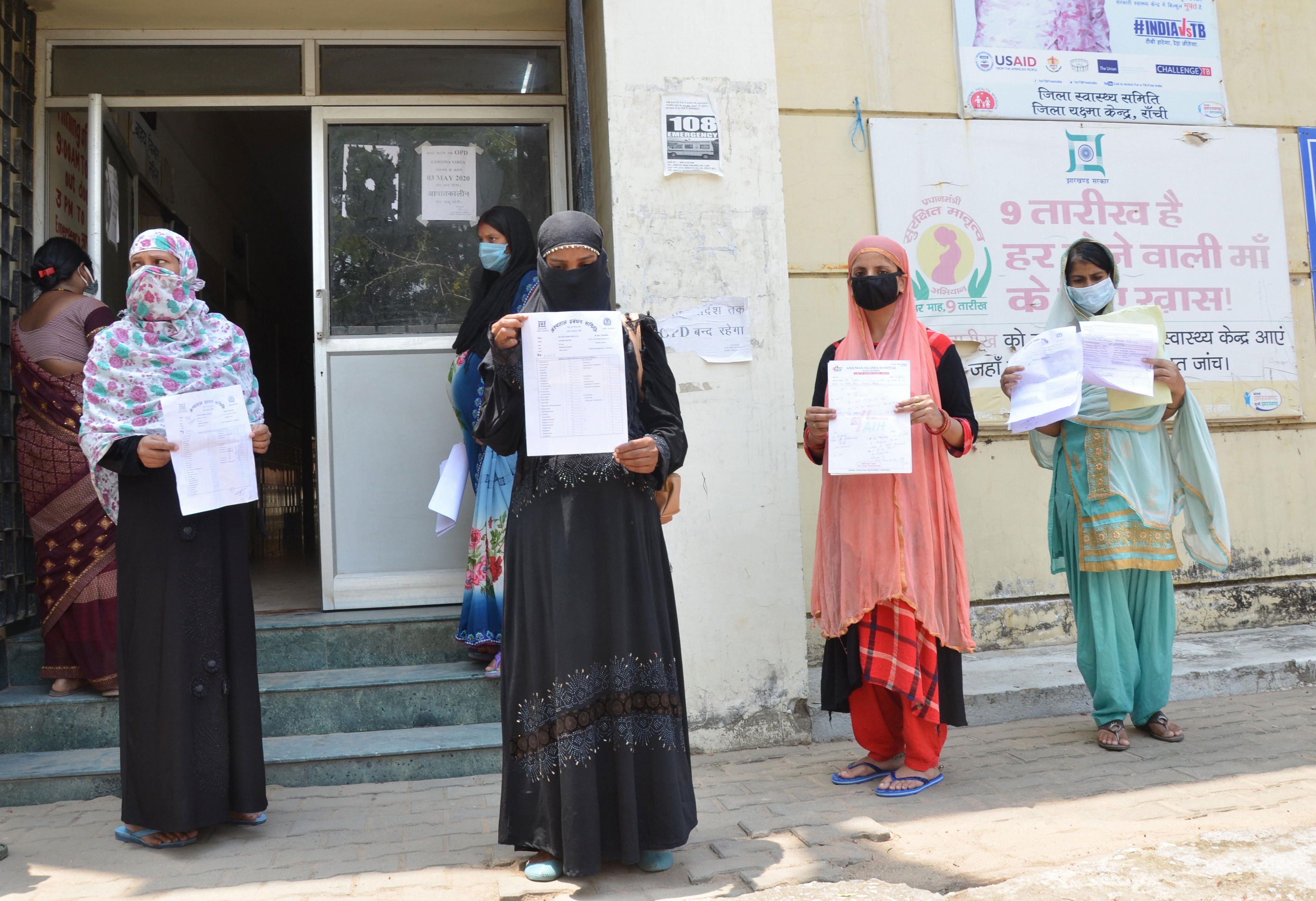 Pregnant women display their prescriptions in which they have been prescribed a COVID19 test by their doctors, in wake of the coronavirus pandemic, in Ranchi, Tuesday, April 28, 2020.