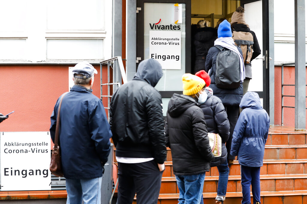 People line up in front of a new set up test and information centre for the new coronavirus at the district Prenzlauer Berg in Berlin, Germany, Monday, March 9, 2020.