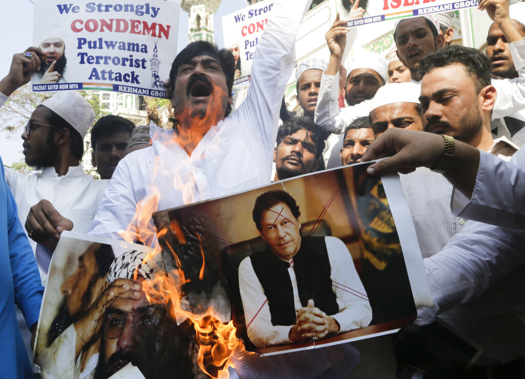 Indian protesters burn posters of Imran Khan and Jaish-e-Mohammad leader Masood Azhar in Mumbai.